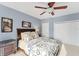 Bedroom with beautiful blue walls, carpet, and a ceiling fan with lighting at 6822 Dominion Ln, Lakewood Ranch, FL 34202