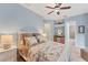 A serene bedroom with soft hues, ceiling fan, and access to the Primary bath at 6822 Dominion Ln, Lakewood Ranch, FL 34202