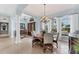 Elegant dining room with a round table, chandelier, and large windows with views of the well manicured exterior at 6822 Dominion Ln, Lakewood Ranch, FL 34202