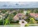 Expansive home features a tiled roof, manicured landscaping, and a circular driveway with palm tree centerpiece at 6822 Dominion Ln, Lakewood Ranch, FL 34202