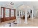 Elegant foyer with tile flooring, a decorative glass door, and a view into the dining room at 6822 Dominion Ln, Lakewood Ranch, FL 34202