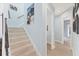 Hallway with carpeted staircase leading to tiled hallway with doorways and wall art at 6822 Dominion Ln, Lakewood Ranch, FL 34202