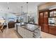 Large kitchen island with seating, wine rack, and views of the living room and screened lanai at 6822 Dominion Ln, Lakewood Ranch, FL 34202