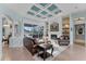 Elegant living room with fireplace, coffered ceiling, and access to screened lanai with lake views at 6822 Dominion Ln, Lakewood Ranch, FL 34202