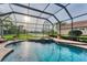 Sparkling screened-in pool and spa offers a tranquil view of the lush backyard and a serene lake at 6822 Dominion Ln, Lakewood Ranch, FL 34202