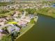 Waterfront home with a screened lanai pool surrounded by well-maintained landscaping and a serene lake view at 711 Planters Manor Way, Bradenton, FL 34212
