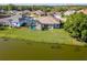 Aerial view of a house with a screened-in pool, lake, and well-maintained lawn at 711 Planters Manor Way, Bradenton, FL 34212