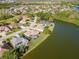 Aerial view of a neighborhood with houses situated along a lake and a golf course at 711 Planters Manor Way, Bradenton, FL 34212