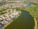 Aerial view of homes situated on a lake and near a golf course, showcasing a community lifestyle at 711 Planters Manor Way, Bradenton, FL 34212