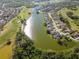 Aerial view of a neighborhood with a lake and golf course offering waterfront living and recreational opportunities at 711 Planters Manor Way, Bradenton, FL 34212