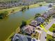 Scenic aerial view of homes backing onto a lake with lush green landscaping and a golf course nearby at 711 Planters Manor Way, Bradenton, FL 34212