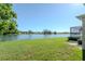 Beautiful backyard featuring a lush lawn and serene lake views, perfect for outdoor relaxation at 711 Planters Manor Way, Bradenton, FL 34212