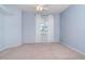 Cozy bedroom with light blue walls, a ceiling fan, and a window overlooking lush greenery at 711 Planters Manor Way, Bradenton, FL 34212