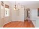 Bright dining room with window, chandelier, and beautiful wood floors at 711 Planters Manor Way, Bradenton, FL 34212