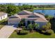 Beautiful lakefront property featuring lush landscaping and a screened lanai at 711 Planters Manor Way, Bradenton, FL 34212