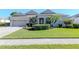 Attractive home with a spacious front lawn, mature trees, and a welcoming entrance at 711 Planters Manor Way, Bradenton, FL 34212
