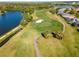 Scenic aerial view of the golf course with lush green fairways, a water hazard, and manicured landscape at 711 Planters Manor Way, Bradenton, FL 34212