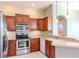 Well-lit kitchen features stainless steel appliances, wood cabinets and a breakfast bar at 711 Planters Manor Way, Bradenton, FL 34212