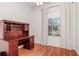 Home office with a classic wooden desk, hardwood floors, and large window with bright light at 711 Planters Manor Way, Bradenton, FL 34212