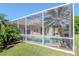 Backyard view showcasing a screened-in pool and lush tropical landscaping at 711 Planters Manor Way, Bradenton, FL 34212