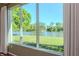 A window showcasing a picturesque view of a lush green lawn and a serene lake at 711 Planters Manor Way, Bradenton, FL 34212