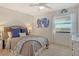 Bright bedroom with a ceiling fan, a large bed, an abstract painting, and a view through the window at 755 S Palm Avenue # 604, Sarasota, FL 34236