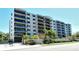 Apartment complex with balconies; a gated entrance is framed by lush, tropical landscaping at 755 S Palm Avenue # 604, Sarasota, FL 34236