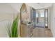 Bright condo entryway with a decorative mirror, table lamp, console table, and an entry door at 755 S Palm Avenue # 604, Sarasota, FL 34236
