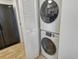 Compact laundry area with stacked washer and dryer units, and next to the pantry space at 755 S Palm Avenue # 604, Sarasota, FL 34236
