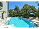 Community pool surrounded by tropical landscaping and lounge chairs at 755 S Palm Avenue # 604, Sarasota, FL 34236