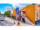 Exterior view of vibrant buildings, a theater, and artistic murals with parked car on a sunny day at 755 S Palm Avenue # 604, Sarasota, FL 34236