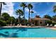 Community pool with lounge chairs, umbrellas, and a cabana under a sunny blue sky at 7783 Limestone Ln # 10-101, Sarasota, FL 34233