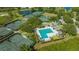 A lovely aerial shot of a community pool, clubhouse, and tennis courts surrounded by lush trees at 7847 Chick Evans Pl, Sarasota, FL 34240