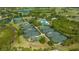 Aerial view of tennis courts and community pool in a golf community with lush landscaping at 7847 Chick Evans Pl, Sarasota, FL 34240