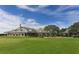 The rear of the impressive clubhouse boasts multiple windows and lovely landscaping at 7847 Chick Evans Pl, Sarasota, FL 34240