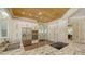 Kitchen with stainless appliances, granite countertops, custom cabinets and wood plank ceiling at 7847 Chick Evans Pl, Sarasota, FL 34240
