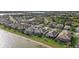 Aerial view of a waterfront home with a screened pool in a well-maintained neighborhood with lake access at 8016 Grande Shores Dr, Sarasota, FL 34240