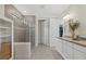 Well lit bathroom with dual sink vanity, walk-in shower, and modern finishes at 8016 Grande Shores Dr, Sarasota, FL 34240