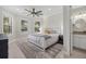 Bright bedroom featuring recessed lights, neutral decor, ensuite bathroom, and water views at 8016 Grande Shores Dr, Sarasota, FL 34240