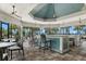 Open clubhouse with a bar, tiled floor, high ceilings, many ceiling fans, and views of palm trees at 8016 Grande Shores Dr, Sarasota, FL 34240