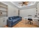 Cozy den featuring a murphy bed, built-in bookshelves, a ceiling fan and a modern desk at 8016 Grande Shores Dr, Sarasota, FL 34240