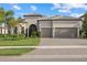 Charming single-story home with a tile roof, arched entry, three-car garage and well-manicured landscaping at 8016 Grande Shores Dr, Sarasota, FL 34240