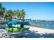 Lakeside kayak rack with two kayaks and a view of the water, the beach, and palm trees at 8016 Grande Shores Dr, Sarasota, FL 34240