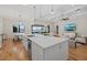Modern kitchen with white cabinetry, stainless steel appliances, large island, and view of the water at 8016 Grande Shores Dr, Sarasota, FL 34240