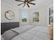 Bright main bedroom featuring a decorative ceiling fan, white bedding, and outside views from multiple windows at 8016 Grande Shores Dr, Sarasota, FL 34240