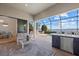 Expansive screened lanai featuring full outdoor kitchen, a pool overlooking the lake and an interior living area at 8016 Grande Shores Dr, Sarasota, FL 34240