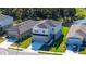 Aerial view showcasing a gray home with a two-car garage near a serene pond at 8918 Waxwing Way, Parrish, FL 34219