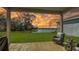 Enjoy peaceful lake views from this backyard patio with cozy seating at sunset at 8918 Waxwing Way, Parrish, FL 34219