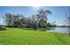 Lush green backyard with a serene lake and mature trees creating a peaceful outdoor space at 8918 Waxwing Way, Parrish, FL 34219