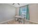 Bright bedroom with a white desk near the window and a ceiling fan at 8918 Waxwing Way, Parrish, FL 34219